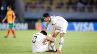 Pemain Timnas Indonesia U-17, Aulia Rahman (kanan) memberikan semangat kepada rekan satu timnya, Arkhan Kaka setelah dikalahkan Timnas Maroko U-17 dalam laga pamungkas Grup A Piala Dunia U-17 2023 yang berlangsung di Stadion Gelora Bung Tomo, Surabaya, Kamis (16/11/2023). (Bola.com/Bagaskara Lazuardi)