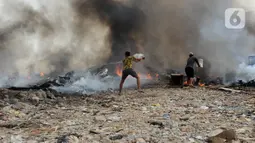 Sebelum petugas pemadam kebakaran datang, warga berusaha memadamkan api dengan air kali menggunakan ember. (merdeka.com/Imam Buhori)