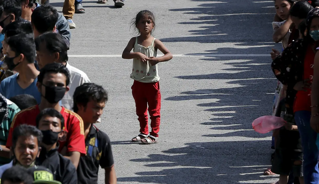 Seorang anak mengantre di antara barisan korban gempa lainnya untuk mendapatkan makanan di lokasi pengungsian, di Kathmandu, Nepal, Senin (4/5/2015).Gempa berkekuatan 7,8 yang meluluhlantakkan Nepal pada 25 April 2015 lalu. (REUTERS/Adnan Abidi)