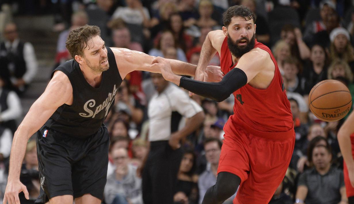 Pemain San Antonio Spurs, Pau Gasol (kiri) berebut bola dengan pemain Chicago Bulls,  Nikola Mirotic pada lanjutan laga NBA di AT&T Center, (25/12/2016). San Antonio Spurs menang 119-100. (AP/Darren Abate)