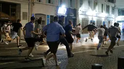 Sejumlah suporter berlari saat terjadi bentrok saat pembukaan Euro 2016  di kawasan bar Marseille, Prancis (10/6). Bentrokan ini mengakibatkan kerusakan sejumlah fasilitas bar dan jalan di Vieux Port. (REUTERS / Eddie Keogh)