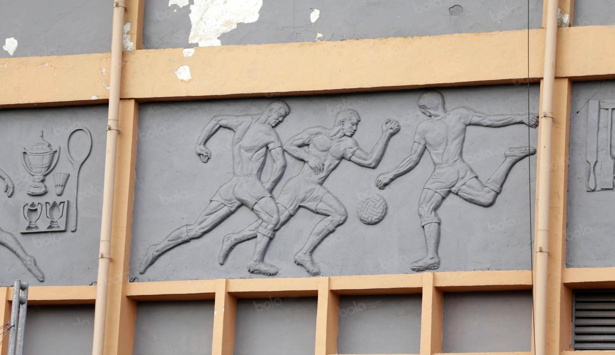 Salah satu pahatan yang menggambarkan orang sedang bermain bola  terpampang pada stadion Gelora 10 November Surabaya di Surabaya, Jumat (10/6/2016). (Bola.com/Nicklas Hanoatubun)