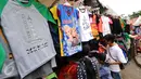 Beberapa warga berburu kaos souvenir di kawasan Monumen Nasional, Jakarta, Minggu (25/12). Libur perayaan Natal 2016 dimanfaatkan sejumlah warga untuk berwisata di kawasan Monumen Nasional. (Liputan6.com/Helmi Fithriansyah)