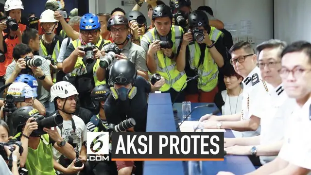 Sejumlah jurnalis foto menggunakan perlengkapan keamanan berupa masker dan helm saat mengahdiri konferensi pers kepolisian Hong Kong. Ini bentuk protes mereka terkait aksi kekerasan aparat terhadap pers.