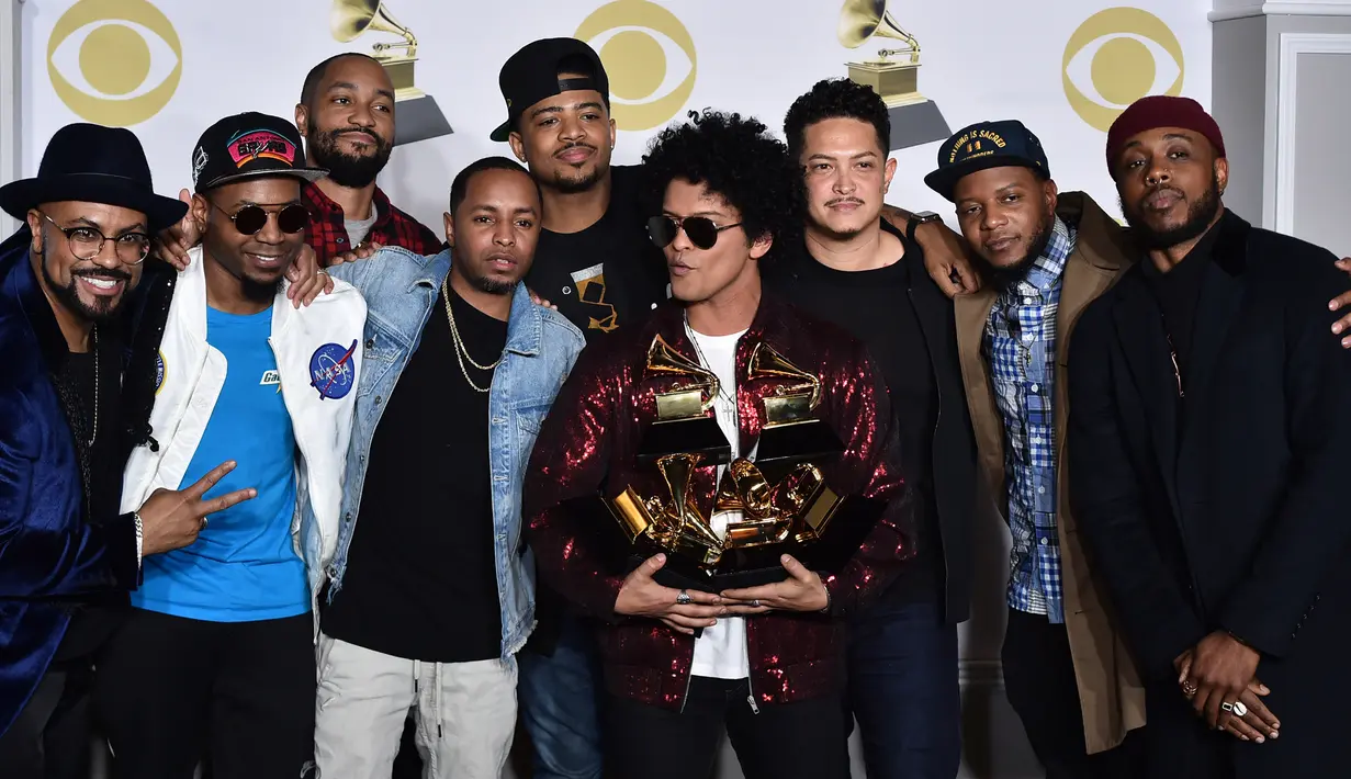 Bruno Mars dan kolaborasi para musisi berpose dengan trofi Grammy Awards 2018 di New York City, Minggu (28/1). Bruno dinominasikan dalam enam kategori, dan sukses menyapu bersih seluruhnya, termasuk tiga kategori utama Grammy. (Charles Sykes/Invision/AP)