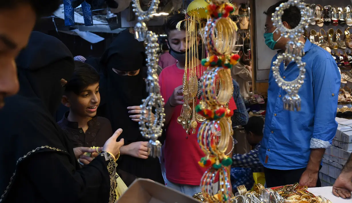 Warga berbelanja jelang Hari Raya Idul Fitri di sebuah pasar di Lahore, Pakistan, Selasa (19/5/2020). Pasar terpantau ramai setelah pemerintah Pakistan melonggarkan lockdown karena pandemi virus corona COVID-19. (Arif ALI/AFP)