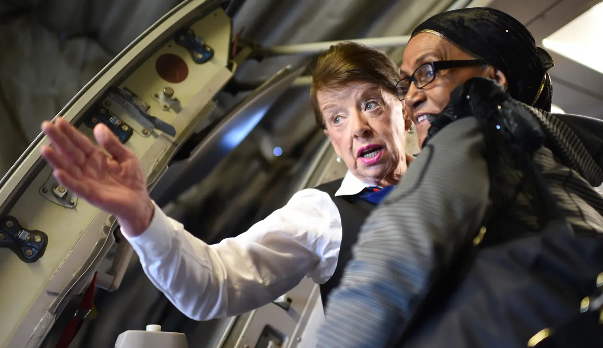 Pramugari Bette Nash memberi petunjuk kepada penumpang sebelum penerbangan ke Boston di Bandara Ronald Reagan Washington di Arlington, Virginia (19/21). Bette Nash telah melintasi langit selama enam dekade sebagai pramugari. (AFP Photo/Eric Baradat)