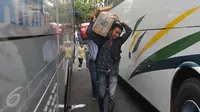 Pemudik tampak membawa barang bawaannya di terminal Pulogadung, Jakarta, Jumat (10/7/15). Pada H -7, terminal Polugadung tercatat memberangkatkan sebanyak 521 penumpang dan bus yang diberangkatkan sekitar 118 bus. (Liputan6.com/Herman Zakharia)