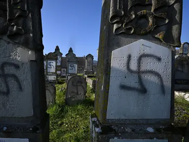 Lambang swastika Nazi pada nisan di pemakaman Yahudi, Westhoffen, dekat Strasbourg, Prancis, Rabu (4/12/2019). Sedikitnya 107 makam menjadi sasaran vandalisme dengan dicoreti lambang swastika Nazi. (AFP/Patrick Hertzog)