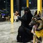 Seorang perempuan duduk dengan anjing herdernya di kafe "Barking Lot" di kota pesisir Khobar, Arab Saudi,  25 September 2020. Pemilik anjing di Arab Saudi kini dapat menikmati secangkir kopi bersama hewan kesayangan di kafe baru, sekaligus yang pertama di negara konservatif itu (FAYEZ NURELDINE/AFP)