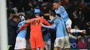 Pemain Manchester City merayakan kemenangan mereka atas Leicester City setelah perempat final Piala Liga Inggris di Stadion King Power, Rabu (19/12). Man City melaju ke semifinal usai mengalahkan Leicester City via adu penalti 3-1. (Lindsey PARNABY/AFP)