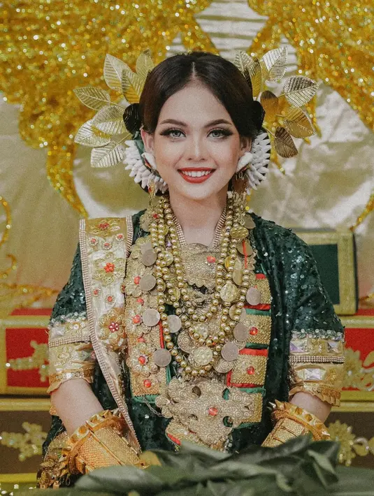 Berbeda lagi dengan penampilan Putri Isnari di Malam Mappacci. Mengenakan baju adat bernuansa hijau keemasan, full makeup Putri Isnari menyempurnakan penampilannya secara keseluruhan. [Foto: Instagram/da4_putri03]