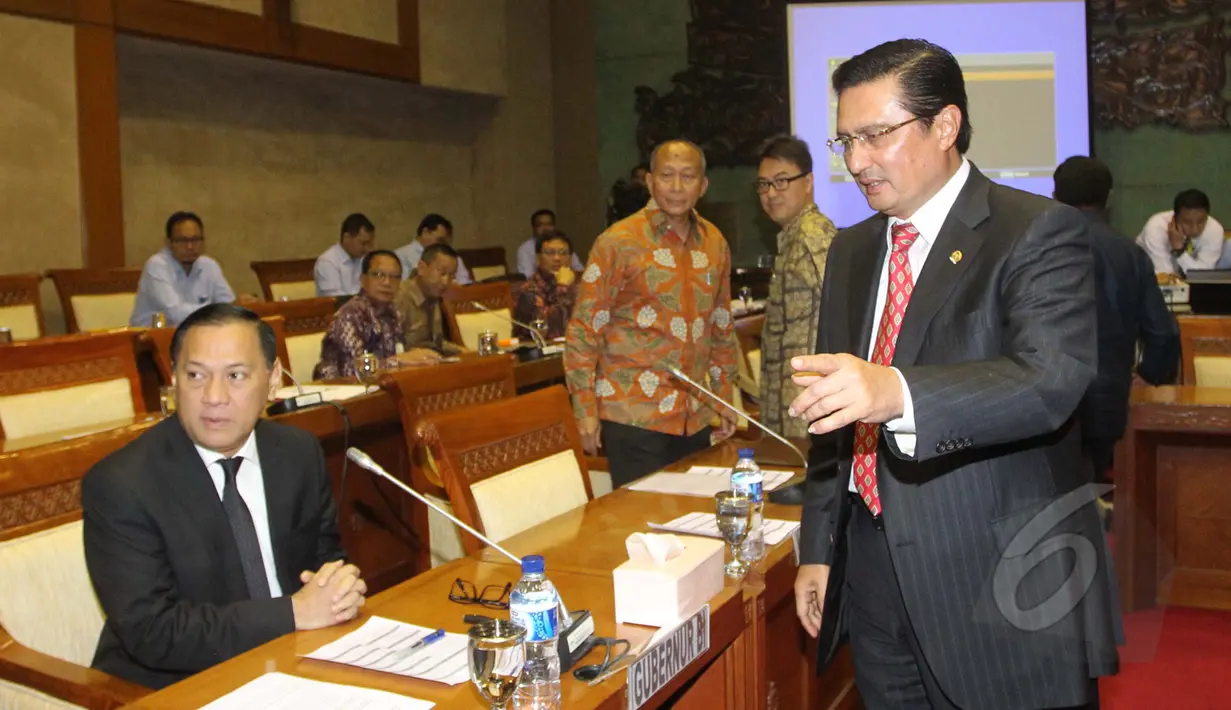 Gubernur BI Agus Martowardojo (kiri) berbincang dengan Kepala OJK, Muliaman D. Hadad sebelum memulai raker dengan Komisi XI DPR RI dan empat lembaga keuangan di Ruang Komisi XI Kompleks Parlemen Senayan, Jakarta, Rabu (25/3/2015). (Liputan6.com/Andrian M 