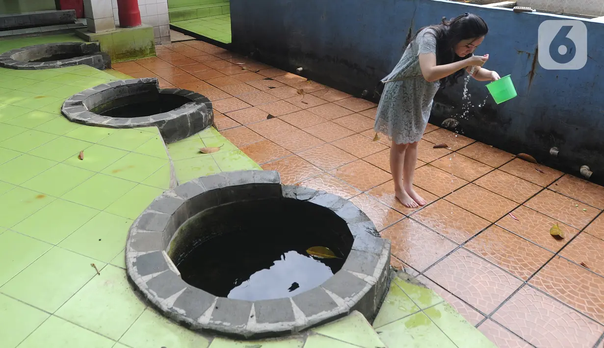 Warga melakukan ritual mandi usai bersembahyang pada perayaan Tahun Baru Imlek 2571 di Vihara Gayatri, Depok, Sabtu (25/1/2020). Pada perayaan Imlek, banyak yang mandi atau sekedar cuci muka, tangan dan kaki di 7 sumur yang dipercaya memiliki keistimewaan tersebut. (merdeka.com/Arie Basuki)