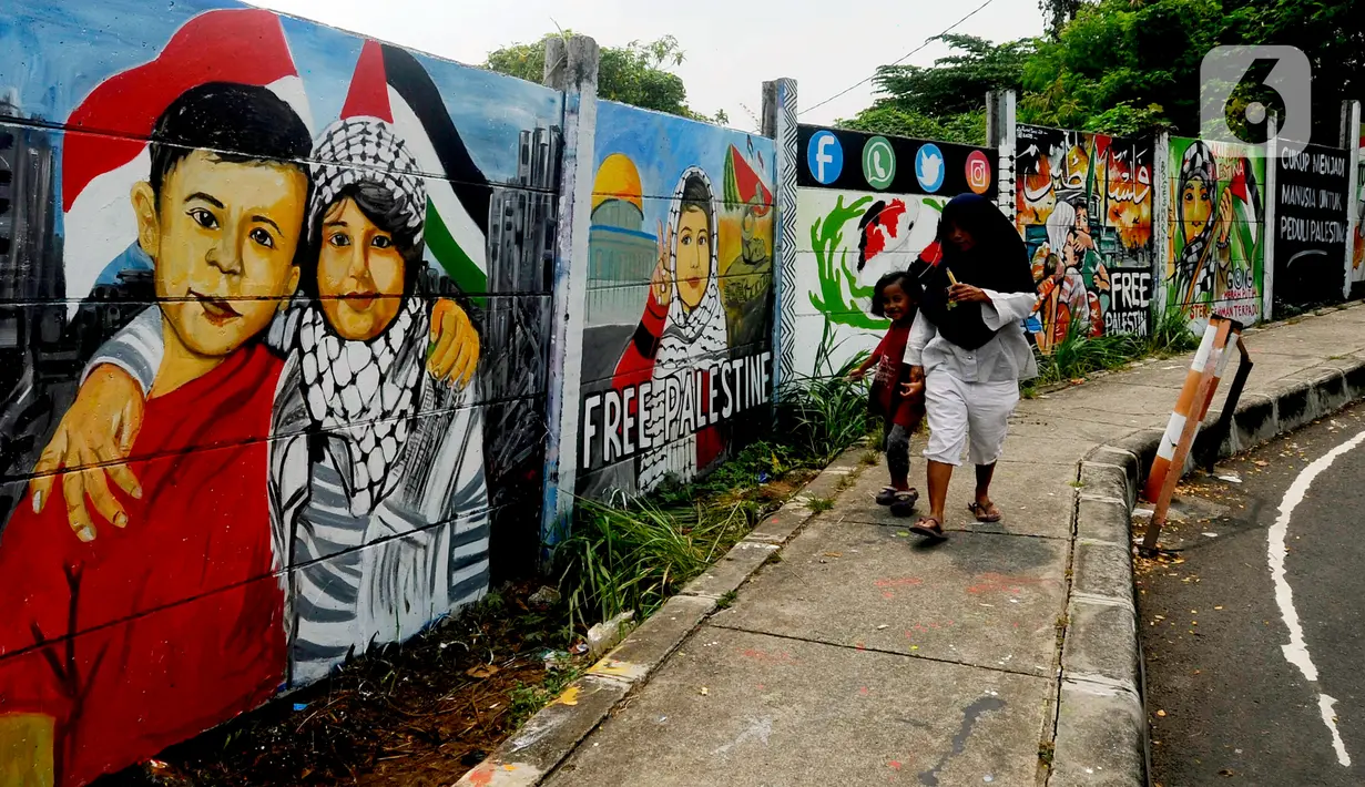 Warga melintas di depan mural solidaritas untuk Palestina di Jalan Juanda, Depok, Jawa Barat, Rabu (8/11/2023). Mural tersebut ditujukan sebagai bentuk solidaritas dan dukungan kepada warga Gaza Palestina atas serangan pasukan Israel. (merdeka.com/Arie Basuki)