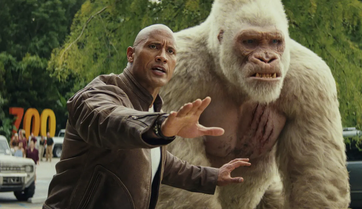 Aktor Dwayne Johnson alias The Rock berjalan bersama seekor gorila dalam adegan film Rampage. (Warner Bros via AP)