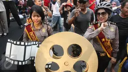 Sejumlah Polisi membawa replika rol film di Bundara HI, Jakarta, Minggu (16/4). Festival digelar agar masyarakat memahami tugas Kepolisian. (Liputan6.com/Angga Yuniar)
