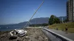 Seorang pelari berlari melewati perahu yang terdampar di Vancouver, British Columbia, Minggu, 7 Juli 2024. (Ethan Cairns/The Canadian Press via AP)