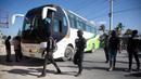 Petugas polisi bersenjata dan bertopeng memaksa seorang pengemudi memarkir busnya untuk digunakan sebagai barikade saat protes untuk mengecam tata kelola polisi yang buruk di Port-au-Prince, Haiti, 26 Januari 2023. Sekelompok polisi Haiti melakukan protes terhadap pemerintah yang dinilai tidak mengambil tindakan tegas atas kematian 14 polisi oleh geng kriminal. (AP Photo/Odelyn Joseph)