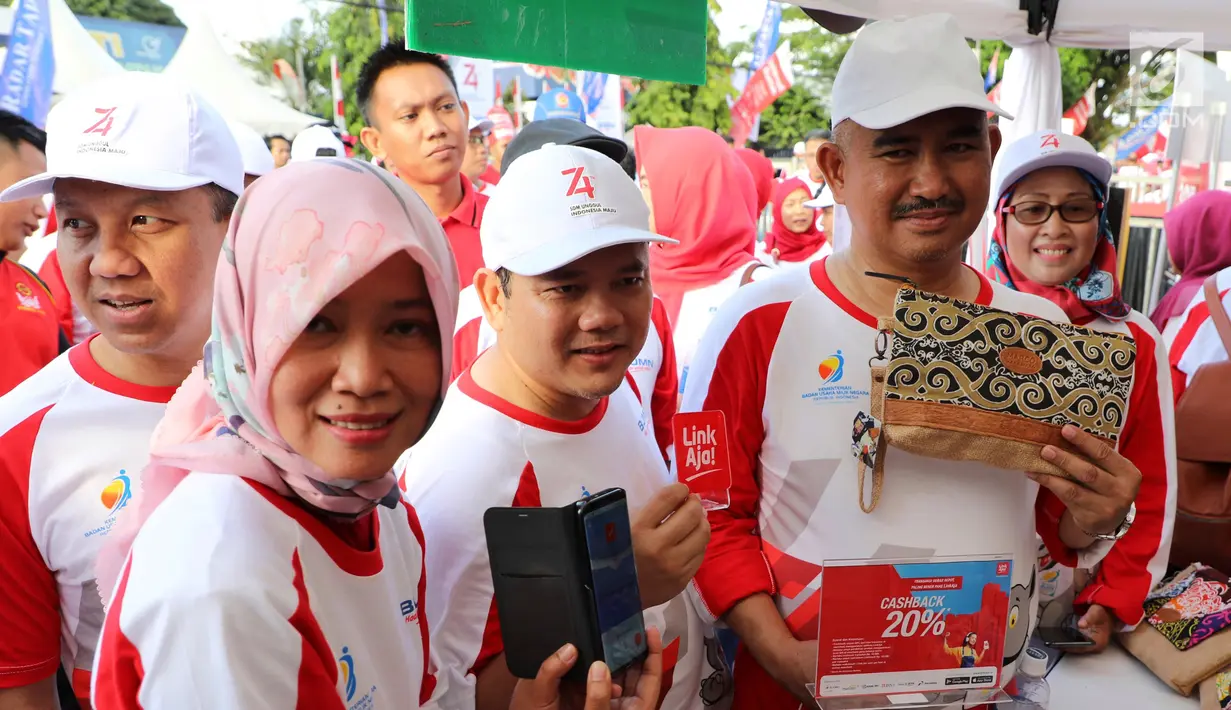 Jajaran Direksi Telkom Indonesia dan Kementerian BUMN berbelanja produk kerajinan di UKM Binaan Telkom menggunakan aplikasi LinkAja pada acara Jalan Sehat BUMN HUT ke-74 RI di Tarakan, Sabtu (17/8/2019). (Liputan6.com/HO/Ady)