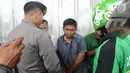 Polisi dan sejumlah pengemudi ojek online menginterogasi terduga copet sebelum dibawa menuju Mapolda Metro Jaya di Jalan Jenderal Sudirman, Jakarta (2/4). (Merdeka.com/Arie Basuki)