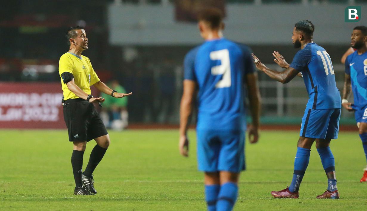 <p>Pemain Timnas Curacao memprotes keputusan wasit&nbsp;Xaypaseth Phongsanit saat laga FIFA Match Day antara Timnas Indonesia melawan Timnas Curacao di Stadion Pakansari, Bogor, Selasa (27/09/2022). (Bola.com/Muhammad Iqbal Ichsan)</p>