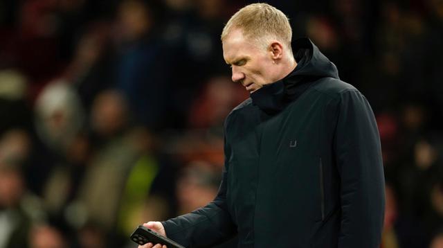 Legenda Manchester United, Paul Scholes, melihat ponselnya sebelum pertandingan Liga Europa antara Manchester United dan Real Sociedad di stadion Old Trafford di Manchester, Inggris, Kamis, 13 Maret 2025. (AP Photo/Dave Thompson)