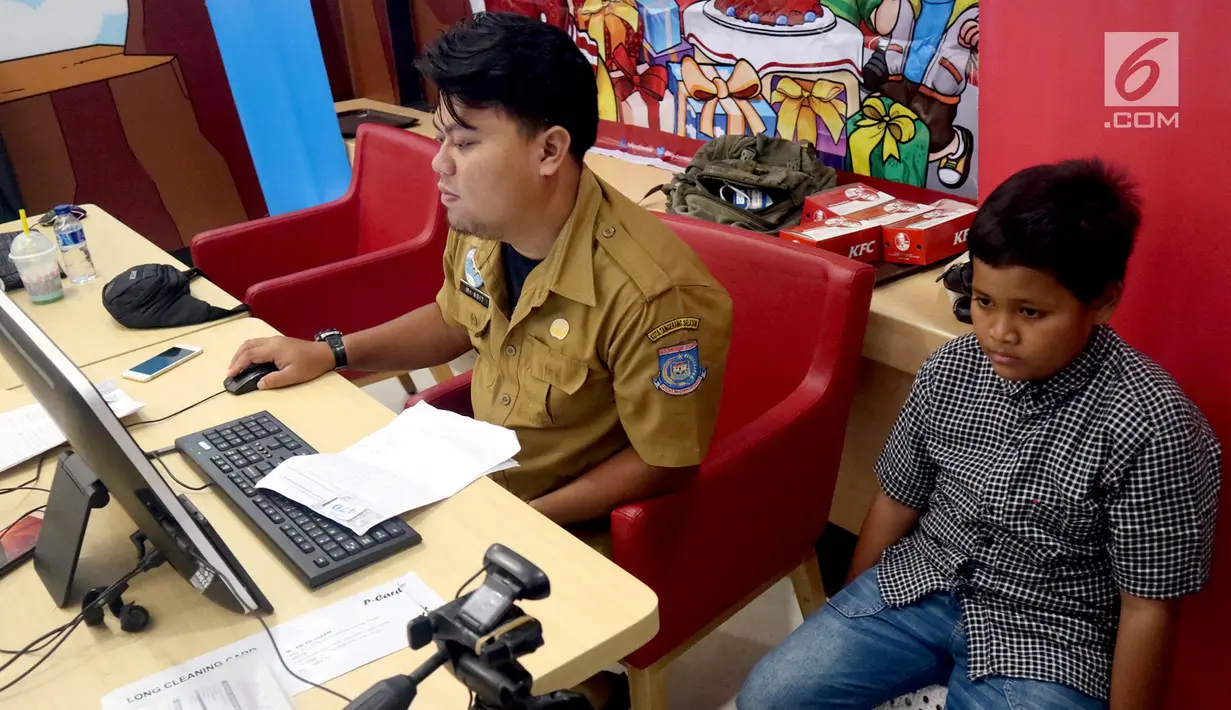 Petugas Disdukcapil Kota Tangerang Selatan melakukan pembuatan Kartu Identitas Anak (KIA) di tempat makan siap saji kawasan Bintaro Tangerang Selatan, Selasa (26/2). (Merdeka.com/Arie Basuki)
