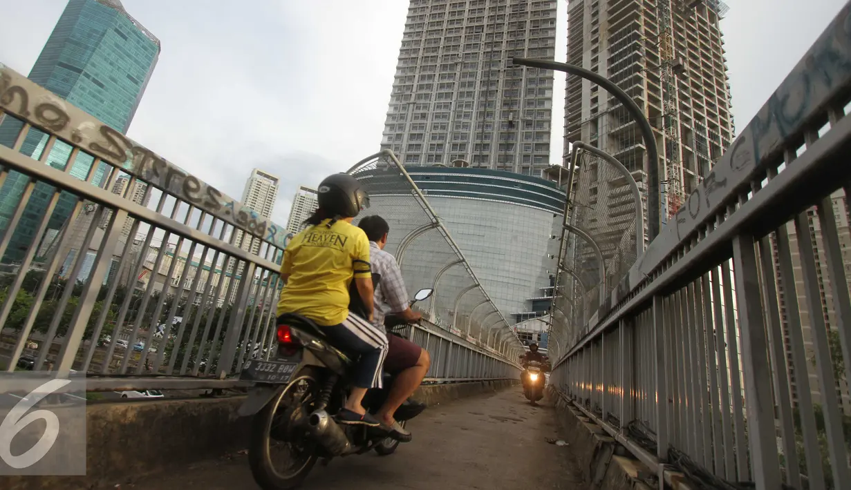 Pengendara sepeda motor melintas di atas Jembatan Penyeberangan Orang (JPO) di kawasan Grogol, Jakarta, Rabu (4/5). JPO yang seharusnya diperuntukkan bagi pejalan kaki itu kini sering dimanfaatkan pengendara motor. (Liputan6.com/Gempur M Surya)