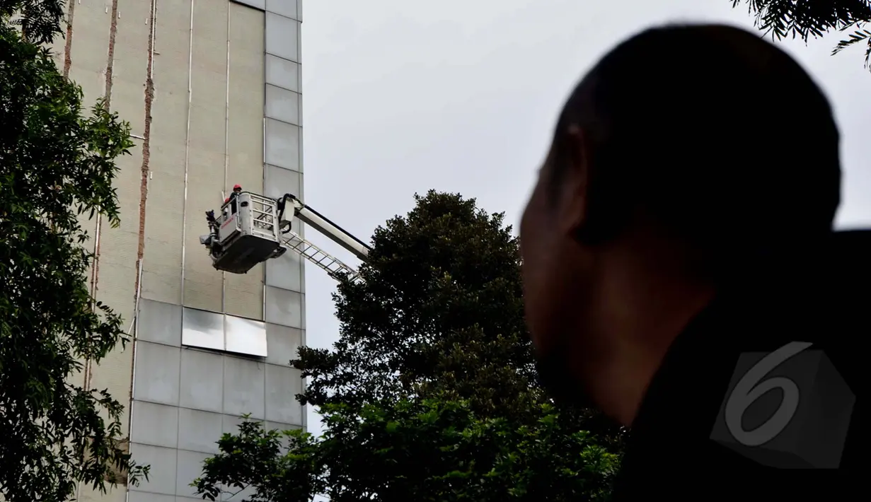 Tampak Seorang warga melihat pelapis dinding  gedung Sekretariat Jenderal DPR RI yang roboh ditiup angin kencang di Kompleks Parlemen, Jakarta, Jumat (24/04/2015). Robohnya dinding karena usia gedung yang sudah lama. (Liputan6.com/Andrian M Tunay)