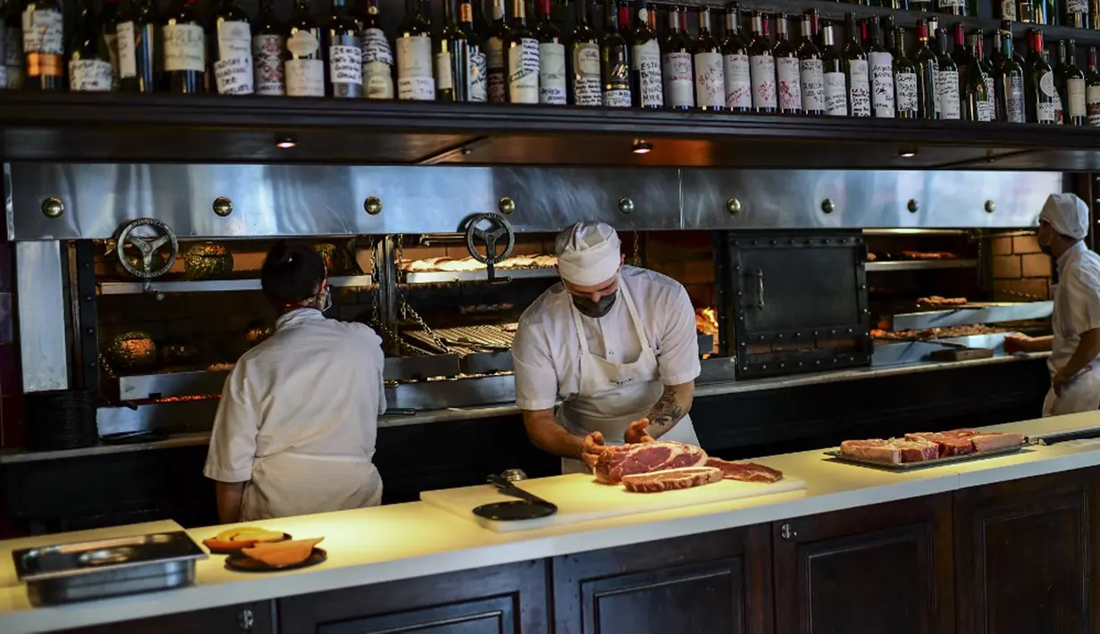 Seorang koki menyiapkan potongan daging untuk dimasak di dapur restoran Don Julio di lingkungan Palermo, Buenos Aires, Argentina, Kamis (20/5/2021). Penghentian ekspor daging sapi Argentina demi mengurangi kenaikan harga pada pasar dalam negeri yang terus melambung. (RONALDO SCHEMIDT/AFP)