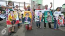Sejumlah seniman mengenakan lukisan-lukisan karya pelukis Hardi yang menyindir ketua DPR Setya Novanto untuk mundur dari jabatannya, Jakarta, Senin (7/12/2015). (Liputan6.com/Yoppy Renato)