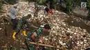 Anggota TNI bersama warga membersihkan  sampah yang menutupi aliran sungai di Kali Baru, Bojonggede, Bogor, Minggu (28/4/2019). Dinas Lingkungan Hidup (DLH) Kabupaten Bogor mengerahkan 50 truk sampah untuk membersihkan sampah yang terbawa banjir dua hari lalu. (merdeka.com/Arie Basuki)