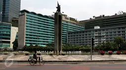 Seorang pedagang tampak melintasi kawasan Bundaran HI, Jakarta, Selasa (1/9/2015). Arus lalu lintas di kawasan Bundaran HI terlihat sepi dari pedemo. (Liputan6.com/Yoppy Renato)