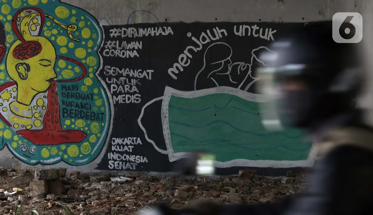Pengendara motor melintas di dekat mural bertema pencegahaan penyebaran virus Corona atau COVID-19 di Jakarta, Selasa (7/4/2020). Mural tersebut menghimbau masyarakat untuk menjaga jarak fisik dan selalu menggunakan masker serta tetap beraktivitas di dalam rumah. (Liputan6.com/Helmi Fithriansyah)