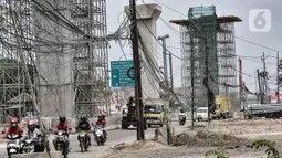 Kendaraan melintas dekat instalasi kabel yang semrawut di Jalan Raya Bekasi, Cakung, Jakarta, Rabu (30/9/2020). Minimnya perawatan pascapembebasan lahan permukiman untuk proyek Tol Dalam Kota membuat jaringan kabel listrik di sepanjang jalan tersebut semrawut. (merdeka.com/Iqbal S. Nugroho)