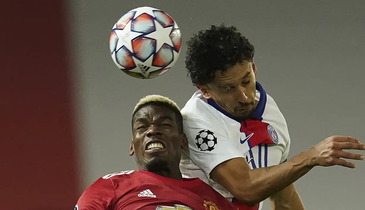 Gelandang Manchester United, Paul Pogba (kiri), berduel udara dengan bek Paris Saint-Germain, Marquinhos, dalam laga lanjutan Liga Champions 2020/21 Grup H di Old Tarfford Stadium, Manchester, Rabu (2/12/2020) waktu setempat. Manchester United kalah 1-3 dari PSG. (AP/Dave Thompson)