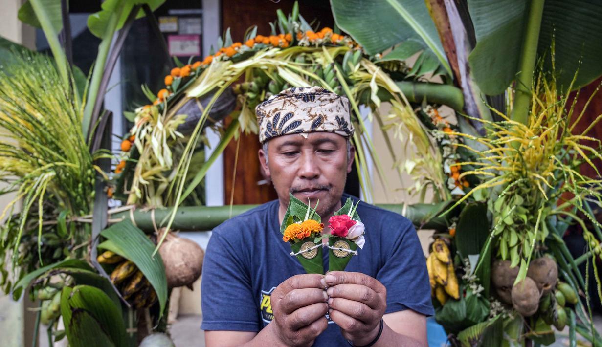 Seorang warga desa menyiapkan persembahan sayuran dan buah-buahan menjelang upacara Yadnya Kasada di Ngadisari, di kaki Gunung Bromo, Jawa Timur, pada Minggu 31 Mei 2026. (JUNI KRISWANTO/AFP)