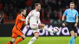 Pemain Denmark Christian Eriksen (tengah) berebut bola dengan pemain Belanda Daley Blind (kiri) disaksikan wasit Lawrence Visser dari Belgia pada pertandingan persahabatan di Johan Cruyff ArenA, Amsterdam, Belanda, 26 Maret 2022. Belanda menang 4-2. (AP Photo/Peter Dejong)