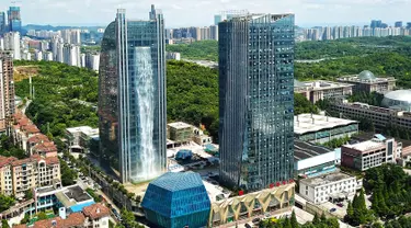 Pemandangan air terjun buatan di sisi gedung pencakar langit Liebian International Plaza di Kota Guiyang, China, 20 Juli 2018. Dengan tinggi yang mencapai 350 kaki atau sekitar 108 meter, itu merupakan air terjun buatan tertinggi sedunia. (AFP/China OUT)
