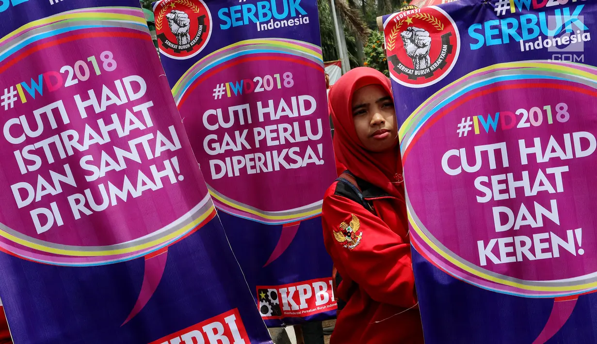 Seorang demonstran Parade Juang Perempuan Indonesia berdiri di samping banner saat demontrasi di depan Gedung DPR, Jakarta, Kamis (8/3). Demonstran meminta pemerintah memperhatikan kesejahteraan dan kemerdekaan perempuan. (Liputan6.com/JohanTallo)