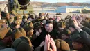 Pemimpin Korea Utara, Kim Jong Un bersama tentaranya usai memimpin peluncuran rudal Pukguksong-2, Minggu (12/2). Kim mengaku puas pada hasil uji coba yang dilakukannya. (AFP PHOTO/KCNA)  