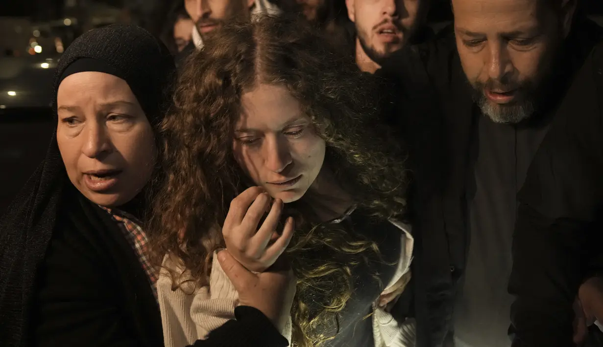 Aktivis Palestina Ahed Tamimi, tengah, disambut oleh ibunya setelah dibebaskan dari penjara oleh Israel, di kota Tepi Barat Ramallah, Kamis (30/11/2023) dini hari. (AP Photo/Nasser Nasser)
