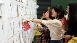 Sejumlah wanita melihat daftar pria lajang saat acara perjodohan di Hangzhou, Provinsi Zhejiang, China (14/5). Para Pria dan wanita mengikuti acara ini dengan harapan mendapatkan pasangan yang sesuai dengan kriterianya. (AFP Photo/Str/China Out)