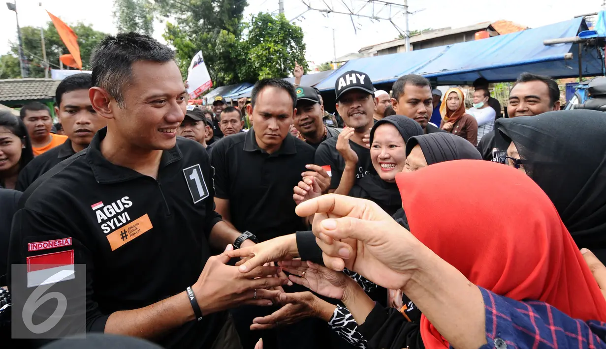 Cagub DKI Jakarta, Agus Harimurti Yudhoyono (kiri) menyalami warga saat sosialisasi di Jalan Menteng Tenggulun, Jakarta, Kamis (22/12). Agus bersosialisasi sambil berkeliling ke beberapa RW di kawasan tersebut. (Liputan6.com/Helmi Fithriansyah)
