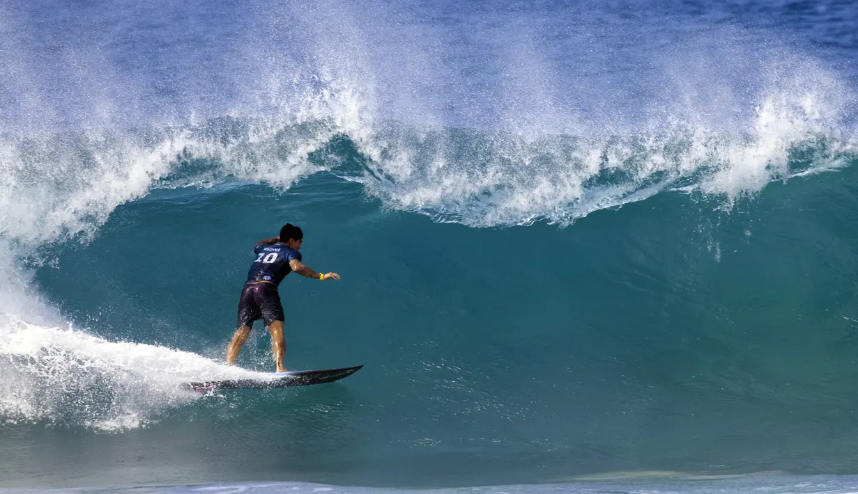 Peselancar Brasil Gabriel Medina mengarungi ombak pada hari pertama Billabong Pipeline Pro di Banzai Pipeline di pantai utara Oahu, Hawaii, pada 1 Februari 2023. Kejuaraan ini berlangsung dari 29 Januari hingga 10 Februari 2023. (AFP/Brian Bielmann)