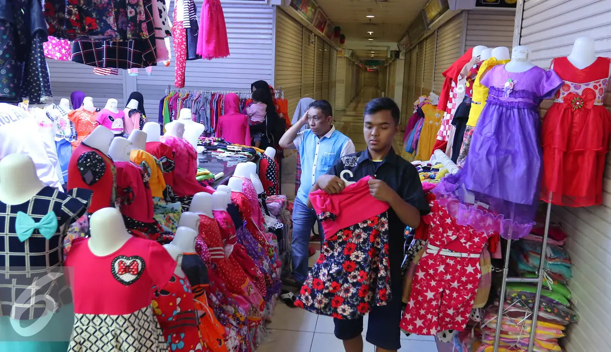 Penjaga toko merapikan baju di Pasar Tanah Abang, Jakarta, Jumat (15/7). Libur Lebaran telah selesai, namun kawasan Blok B Pasar Tanah Abang masih sepi. (Liputan6.com/Angga Yuniar)