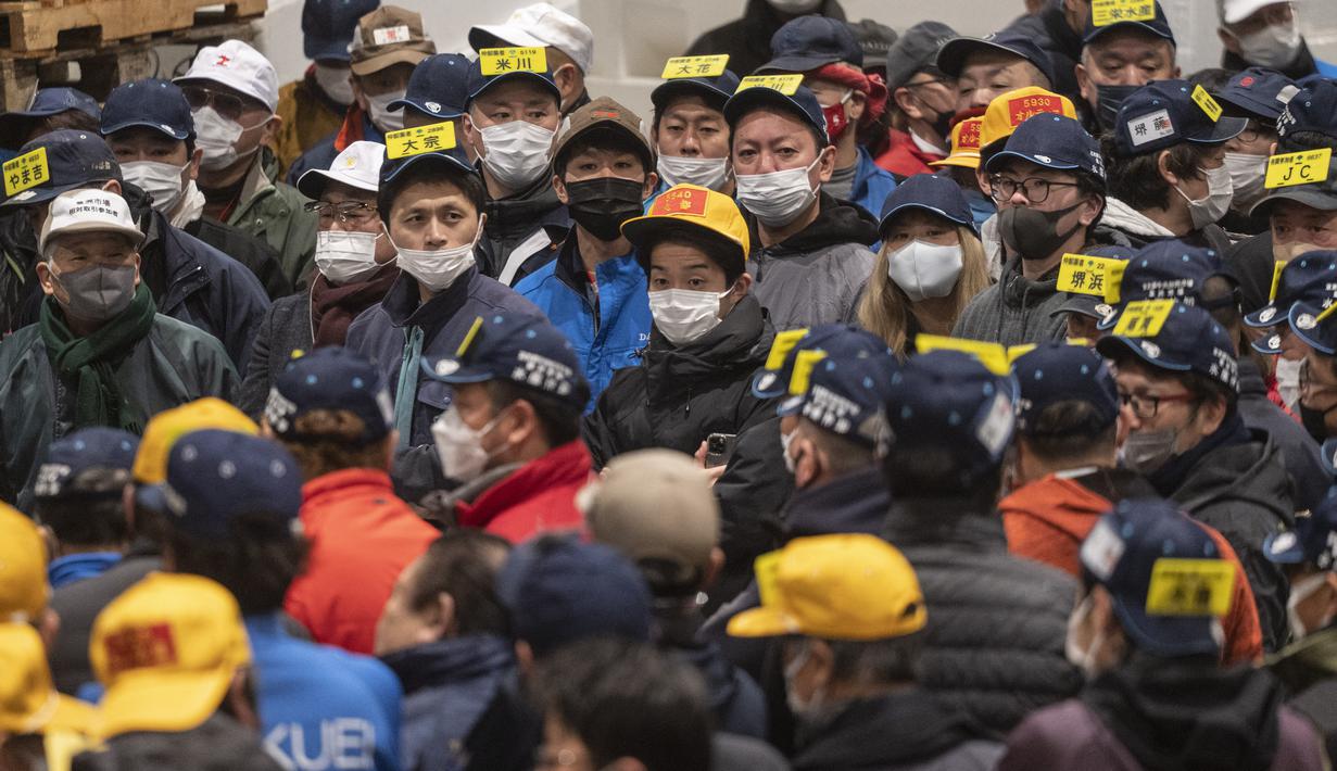 Penjual dan pembeli grosir menghadiri lelang tuna pertama Tahun Baru di pasar ikan Toyosu di Tokyo (5/1/2023). Pada tahun ini, lelang tuna tertinggi terjual lebih dari USD 270.000. Hampir dua kali lipat dari harga tahun lalu. (AFP/Richard A. Brooks)