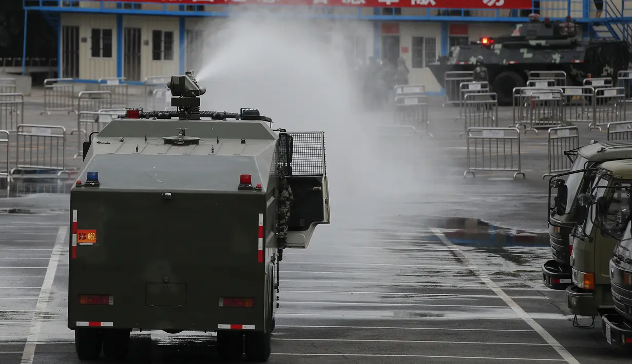 Kendaraan lapis baja  menyemprotkan air saat latihan di Shenzhen, kota di dekat perbatasan dengan Hong Kong, China (30/10/2019). Media milik pemerintah China melaporkan  mereka merupakan bagian dari polisi bersenjata yang bernaung di bawah komando Komisi Militer Pusat. (AP Photo/Andy Wong)