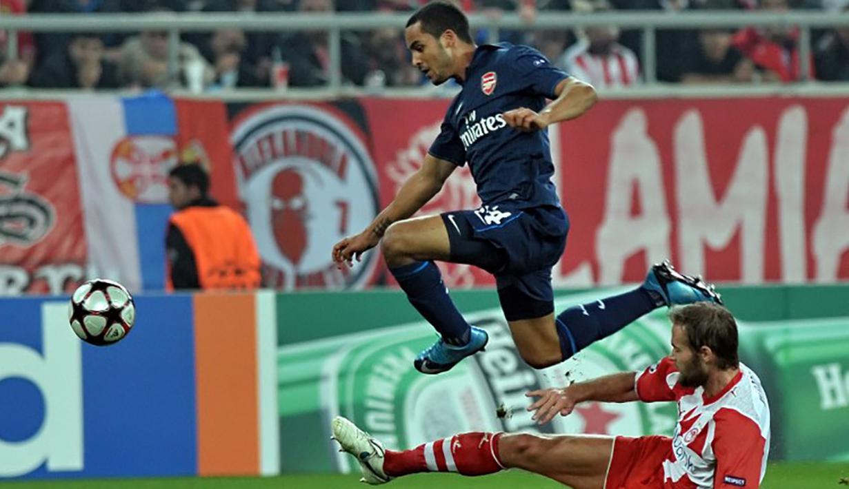 Pemain Arsenal, Theo Walcott melompat menghindari tekel pemain Olympiacos pada laga Liga Champions di Stadion Karaiskaki, Yunani, Kamis (10/12/2009). Walcott memang memiliki kemampuan lari yang cepat. (AFP Photo/Louisa Gouliamaki)